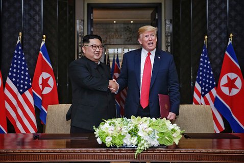 史上初の米朝首脳会談は無事終了。写真は合意文書に調印後、トランプ大統領と金委員長が握手をしている様子 (C)Handout/Getty Images